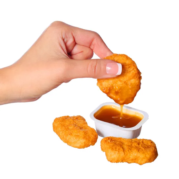Nuggets z kurczaka w ręka i sosem na białym tle — Zdjęcie stockowe
