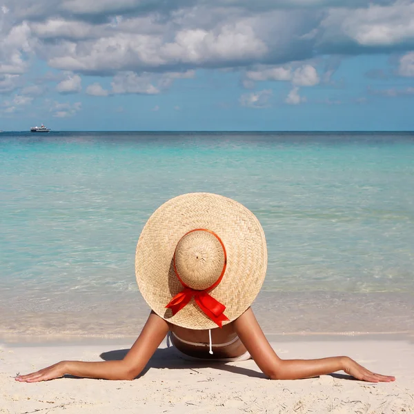 Vacation. Woman in Big Sun Hat tanning and relaxing on Beach Stock Picture