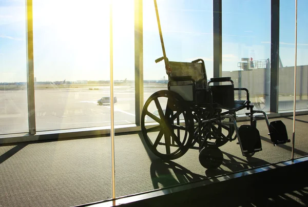 Servicio de silla de ruedas en la terminal del aeropuerto. Vista de la ventana con Sunligh —  Fotos de Stock