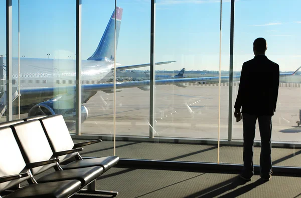 Empresario esperando su vuelo en la terminal del aeropuerto. Silueta —  Fotos de Stock