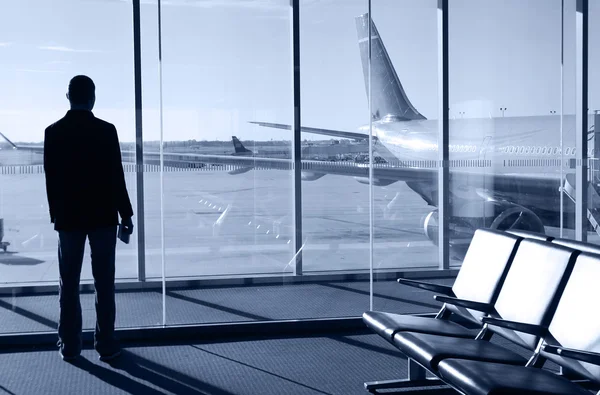 Empresario esperando su vuelo en la terminal del aeropuerto. Silueta —  Fotos de Stock