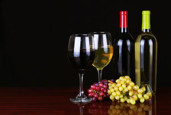 Botellas y copas de vino sobre fondo negro . — Foto de Stock