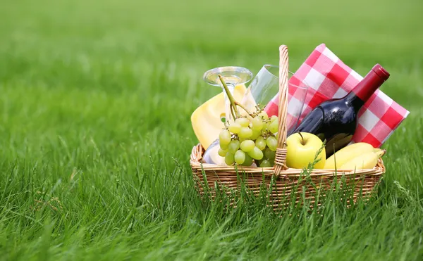 Picnic basket on green grass — Stock Photo, Image