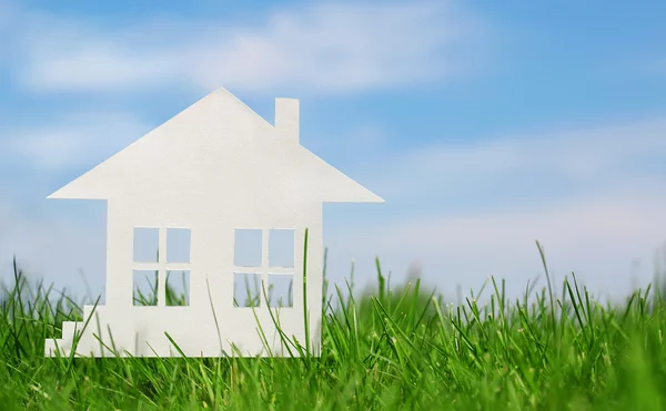 Casa de papel sobre hierba verde sobre cielo azul. Concepto de hipoteca —  Fotos de Stock