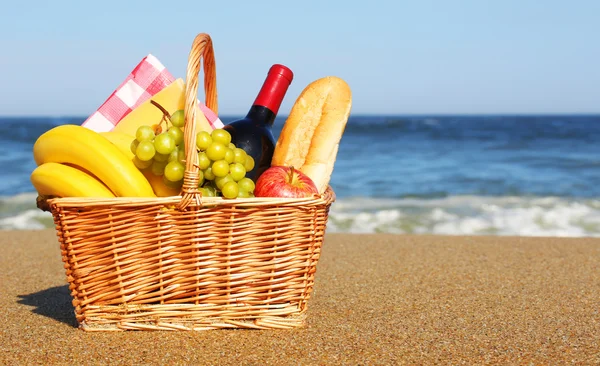 Cesta de piquenique com comida na praia — Fotografia de Stock