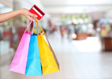 alışveriş! renkli alışveriş torbaları ve kredi tutan el 