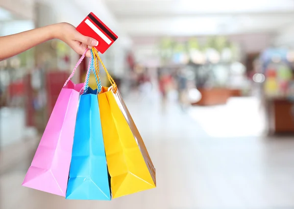 ¡Compras! Bolsas de compras coloridas y crédito de mano femenina —  Fotos de Stock