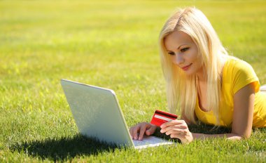 Online alışveriş. laptop ve kredi kartı ile sarışın kız gülümseyerek