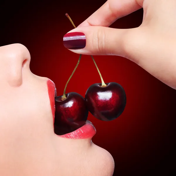 Sexy labios rojos con cereza sobre fondo negro — Foto de Stock