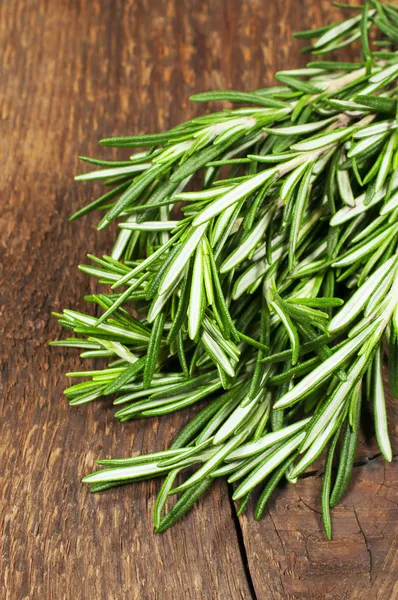 Rosemary em um fundo de madeira — Fotografia de Stock