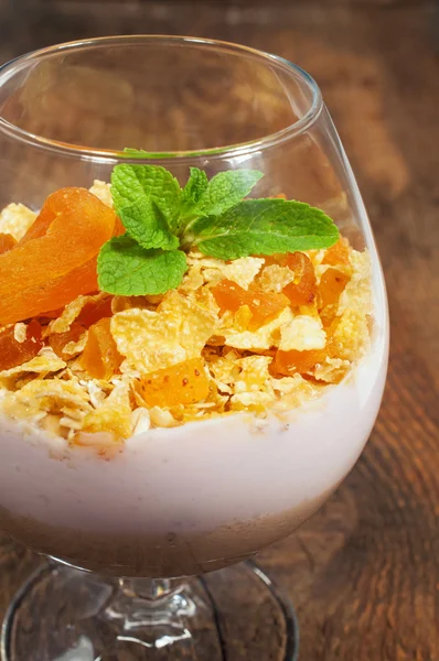 Dessert with muesli , yogurt and dried apricots in a glass — Stock Photo, Image