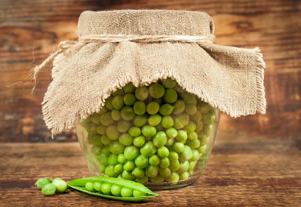 Green peas in glass jar — Stock Photo, Image