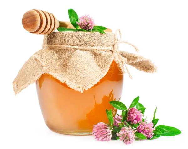 Sweet honey in a glass jar with clover — Stock Photo, Image