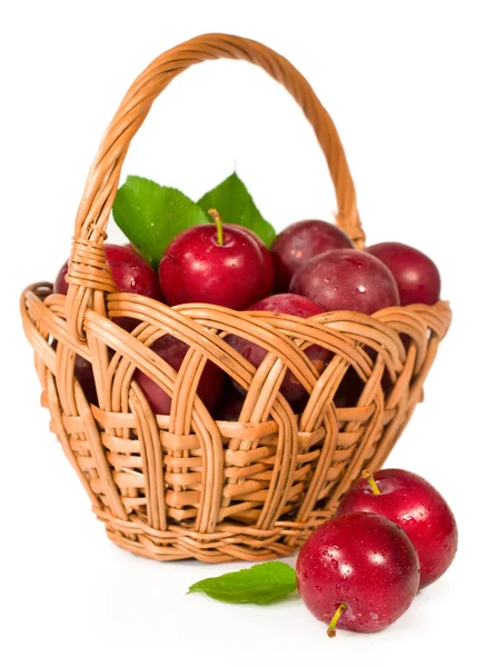 Ripe plums in a wicker basket — Stock Photo, Image