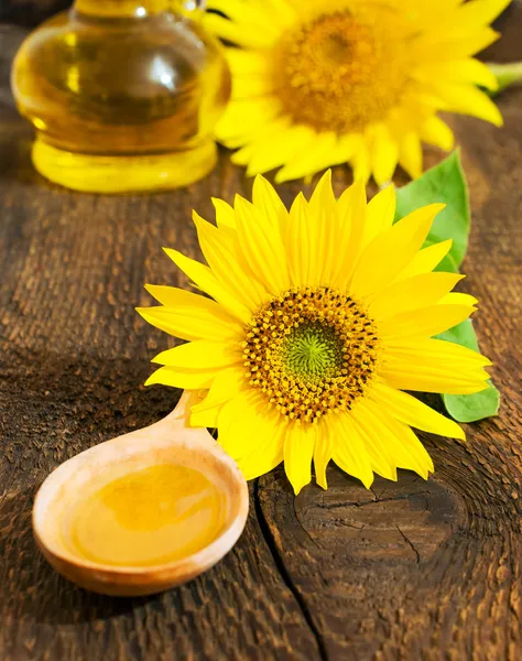 Plantaardige olie in een houten lepel met zonnebloem — Stockfoto