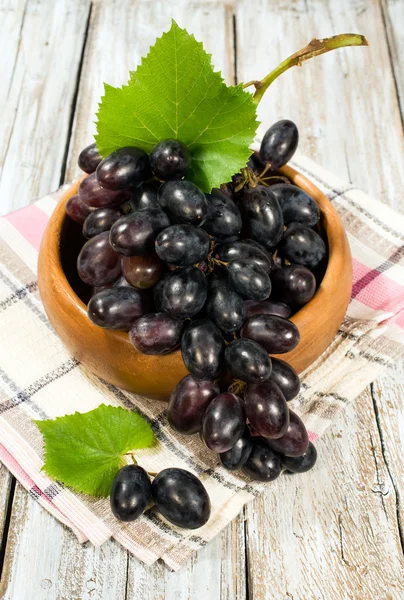 Red ripe grapes in a wooden bowl — Stock Photo, Image