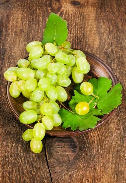 Uvas verdes en un plato de arcilla —  Fotos de Stock