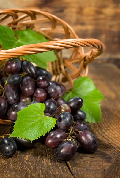 Fresh red grapes in a wooden basket — Stock Photo, Image