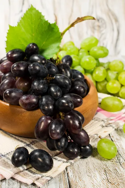 Uvas verdes y rojas frescas en un tazón de madera —  Fotos de Stock