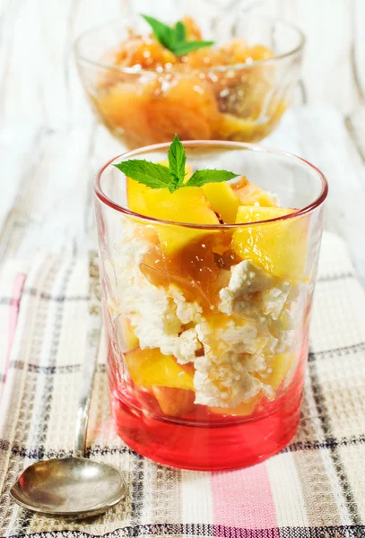 Cottage cheese dessert with peaches in a glass — Stock Photo, Image