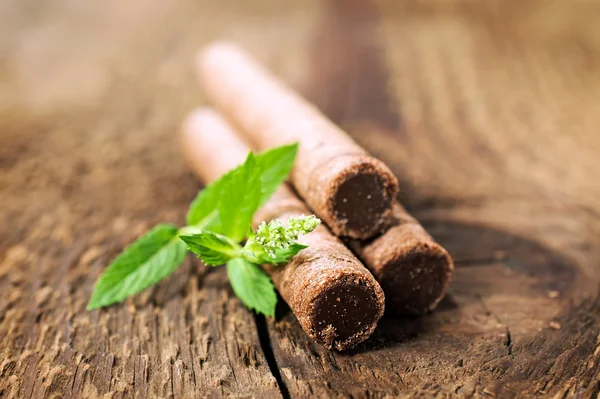 Rolos de wafer de chocolate com close-up de hortelã — Fotografia de Stock