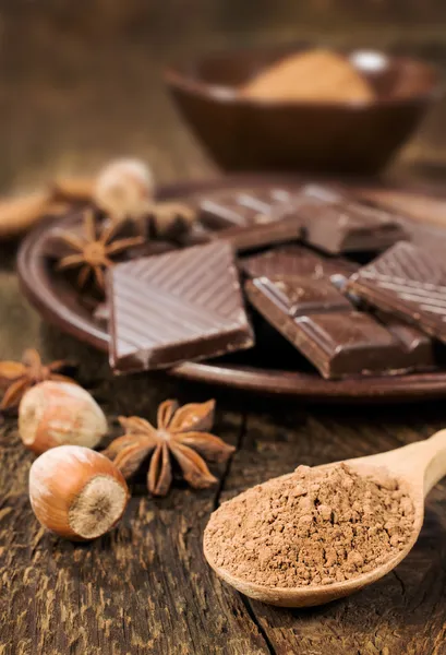 Chocolate, nuts and cocoa powder close up — Stock Photo, Image