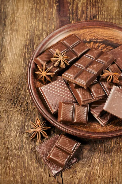 Chocolate and star anise in a clay plate — Stock Photo, Image