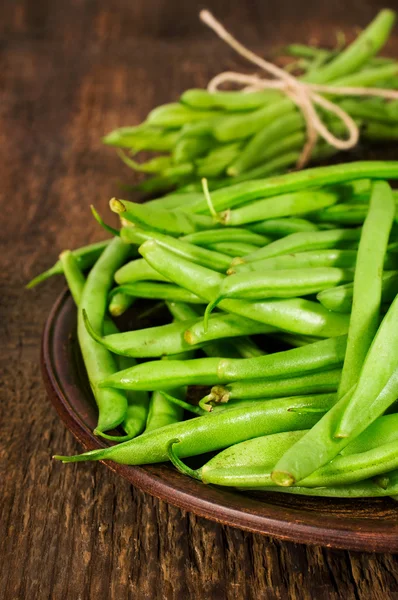 Green beans on a clay plate — Stock Photo, Image