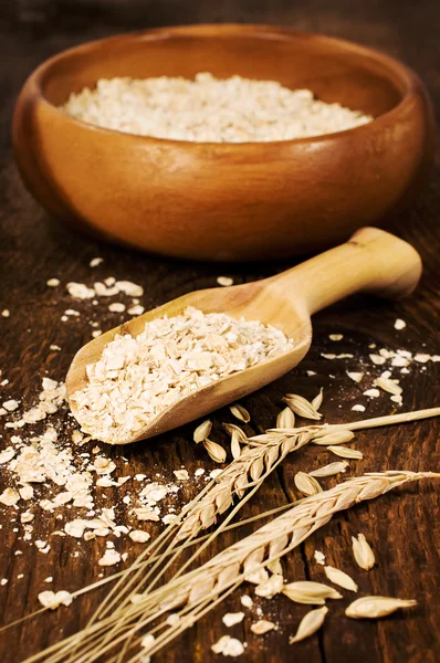 Farinha de aveia com uma colher de espiguetas de trigo — Fotografia de Stock