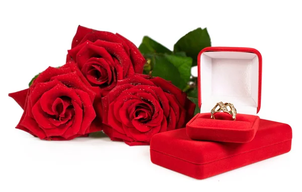 Золоте кільце в червоній подарунковій коробці з букетом троянд — стокове фото