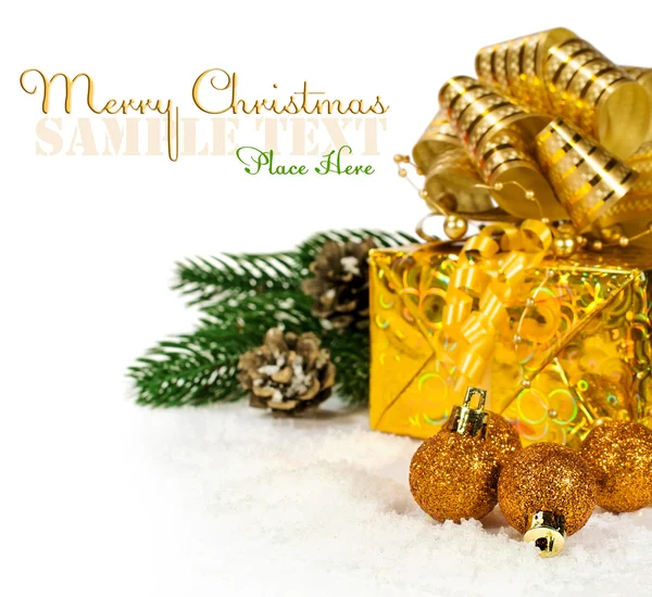 Goldene Weihnachtsgeschenke und Kugeln im Schnee — Stockfoto