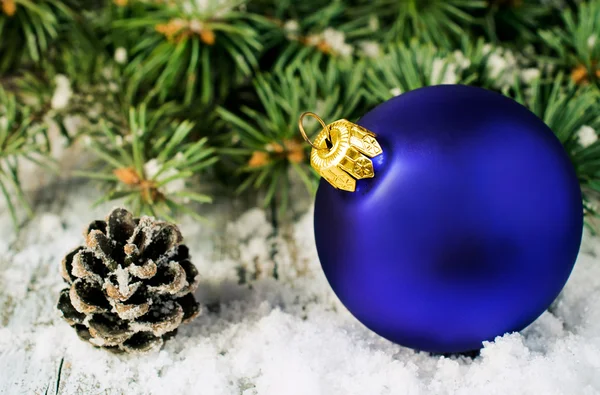 Μπλε Χριστουγεννιάτικη μπάλα και ελάτης υποκαταστήματα στο χιόνι — Φωτογραφία Αρχείου
