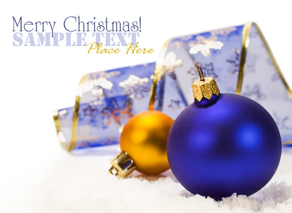 Blauwe en gouden kerstballen en lint in sneeuw — Stockfoto