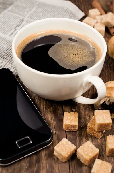 Telefone celular, café e cana-de-açúcar no fundo de madeira — Fotografia de Stock