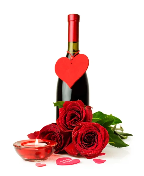 Bir şişe şarap, kırmızı gül ve mum — Stok fotoğraf