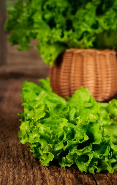 Friss saláta levelek egy fonott kosárban — Stock Fotó