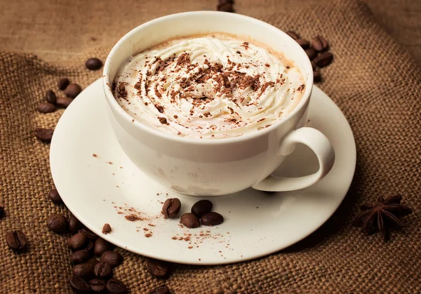 Capuchino sobre fondo de arpillera — Foto de Stock