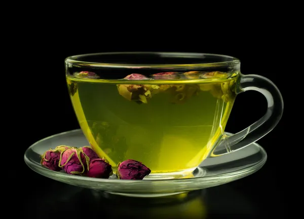 Green tea with rose buds in a glass cup — Stock Photo, Image