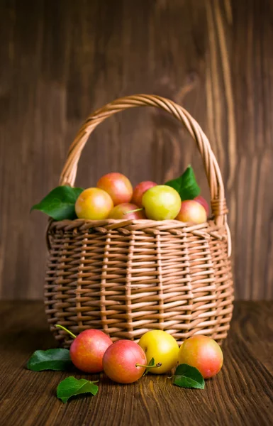 Plums in a wicker basket — Stock Photo, Image