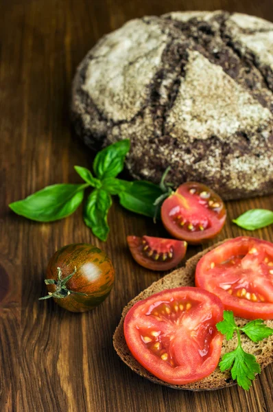 Деревенская еда: сэндвичи с ржаным хлебом с помидорами и базиликом — стоковое фото