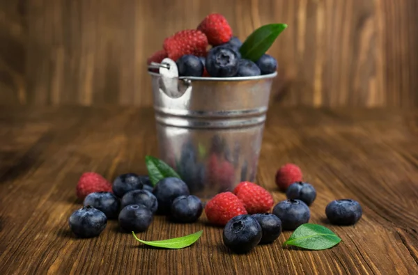 Blaubeeren und Himbeeren in einem kleinen Eimer — Stockfoto