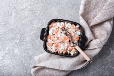 İtalyan rotini makarnasının üst görüntüsü. Beyaz kremalı soslu lezzetli karidesler ve koyu beton arka plan.