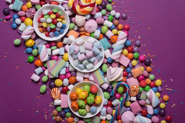 Çok Renkli Tatlı Parlak Dragee Şekerler Lolipoplar Mor Arka Plandaki — Stok fotoğraf