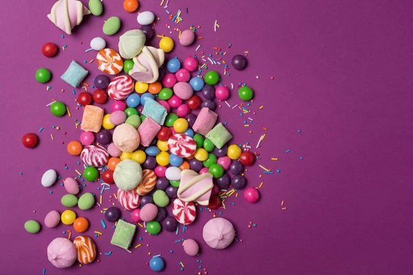 Çok Renkli Tatlı Parlak Dragee Şekerler Lolipoplar Mor Arka Plandaki — Stok fotoğraf