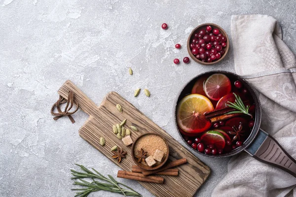 Stock image Autumn or christmas traditional drink with oranges, cranberry, cinnamon, rosemary and other ingredients on grey concrete background