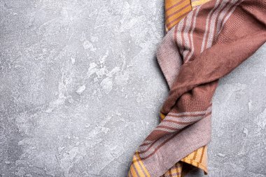 Kahverengi katlanmış mutfak havlusu veya gri beton arka planda peçete manzarası