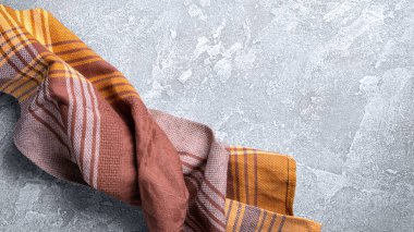 Kahverengi katlanmış mutfak havlusu veya gri beton arka planda peçete manzarası