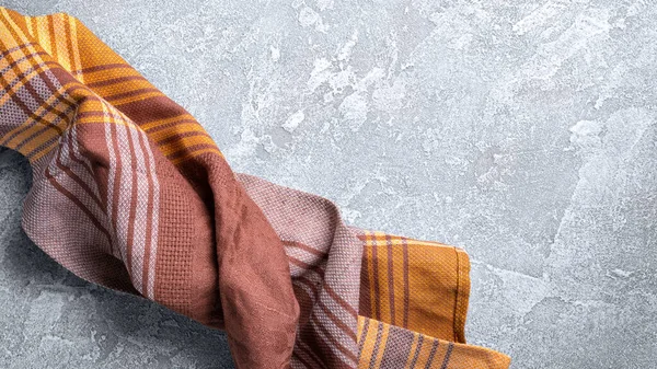 Kahverengi katlanmış mutfak havlusu veya gri beton arka planda peçete manzarası