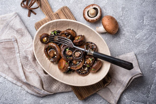 Kavanozda ızgara şampiyon mantarları ve gri beton arka planda baharat.