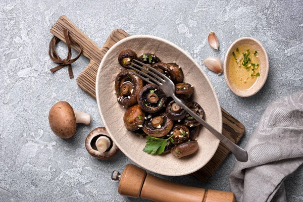 Kavanozda ızgara şampiyon mantarları ve gri beton arka planda baharat.
